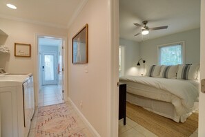 A bedroom with a bed, a ceiling fan, and a window with blinds.