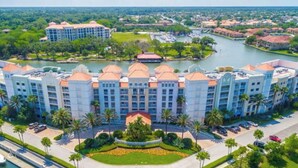Un grand hôtel comprenant plusieurs bâtiments, une cour intérieure et un port de plaisance avec des bateaux.