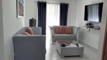 Eenvoudig appartement | Woonkamer | Een 32-inch flatscreentelevisie met kabelzenders en televisie