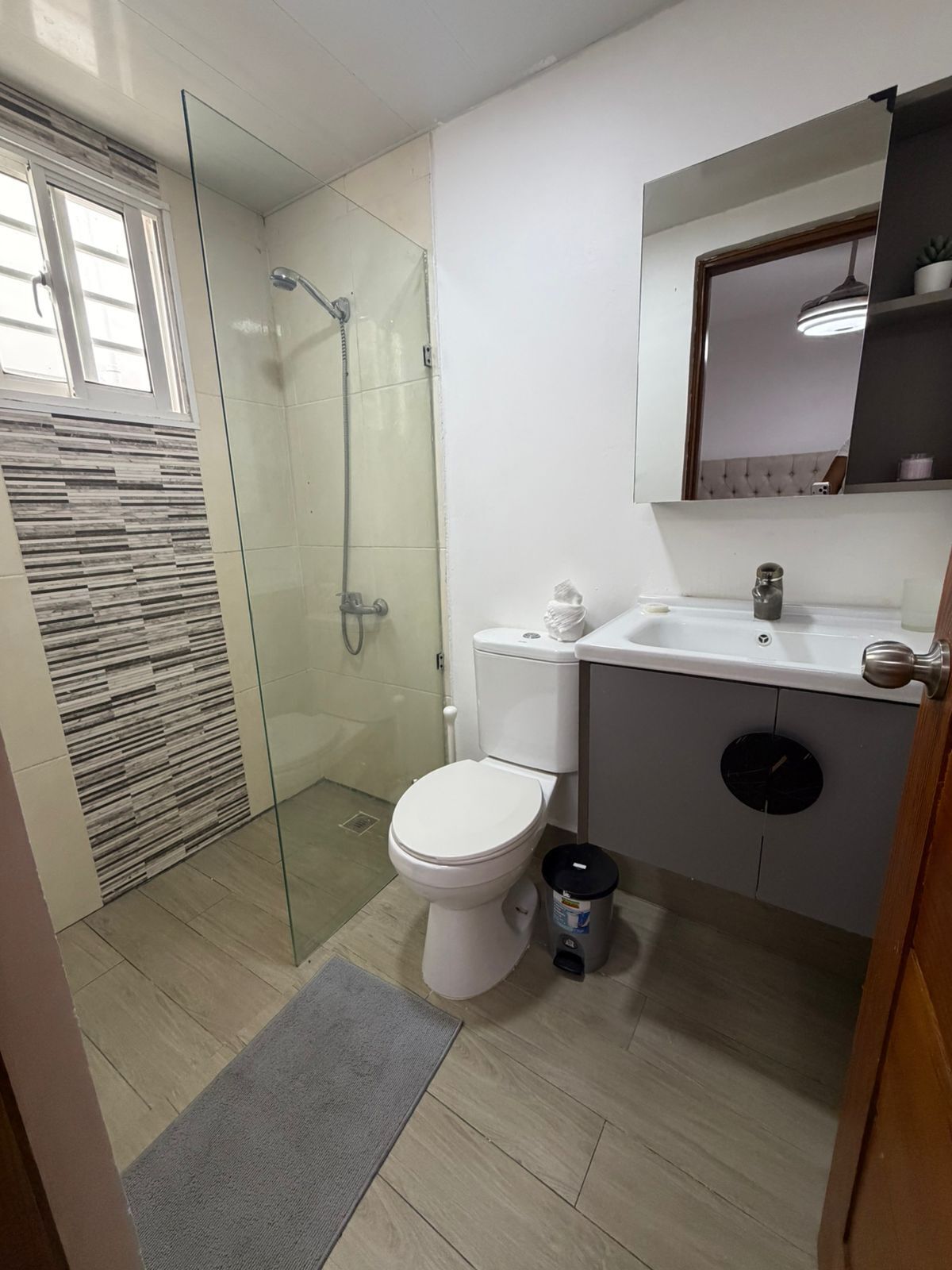A bathroom with a toilet, sink, and shower.