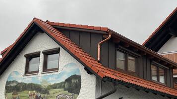 Un bâtiment orné d’une fresque représentant un paysage rural et portant l’inscription « Ennerhof ».