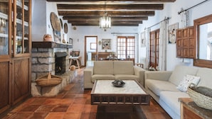 Un salón acogedor con chimenea de piedra, vigas de madera y un sofá.