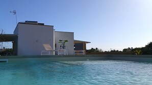 A modern house with a swimming pool, a covered patio, and a clear blue sky. - trullomio.com - Villa Swimming Pool, BBQ, Trullo, Sea view, WiFi (Torre Suda)