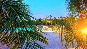 A pathway leading to a pool area surrounded by palm trees and a clear sky. - trullomio.com - Villa Swimming Pool, BBQ, Trullo, Sea view, WiFi (Torre Suda)