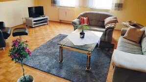 En hyggelig stue med sofa, sofabord og fjernsyn.