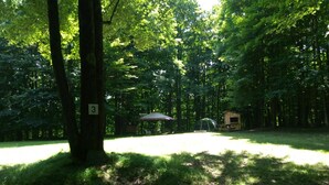 A campground with a picnic table, a tent, and a small wooden structure. - Blue Moon - Dark Skies, Spacious, Quiet, Fully Furnished Campsite (Wellsville)