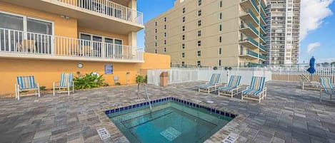 A rooftop pool area with lounge chairs and a swimming pool.