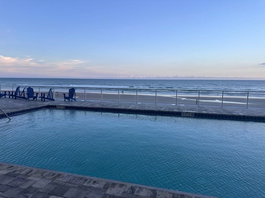 A swimming pool with a view of the beach and ocean.