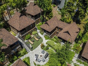 A residential area with multiple houses featuring sloped roofs and a central courtyard with outdoor seating. - Cedar Crest Cottage Near Homewood (Homewood)