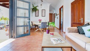A spacious living area with a sofa, coffee table, and dining table.