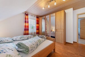 A bedroom with a bed, a wardrobe, and a bathroom visible through a door.