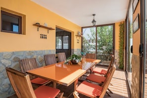 Un espace repas avec une longue table, des chaises en bois et un mur en pierre.