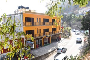 A two-story building with a sign reading "AVLOKAN" and a balcony.