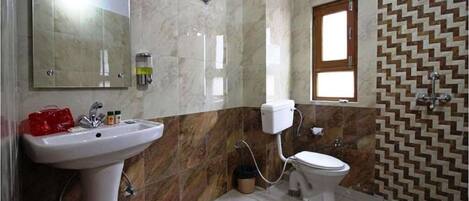 Baño con lavamanos, inodoro y espejo.