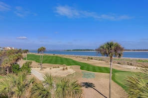 A golf course with a view of the ocean and a clear sky.