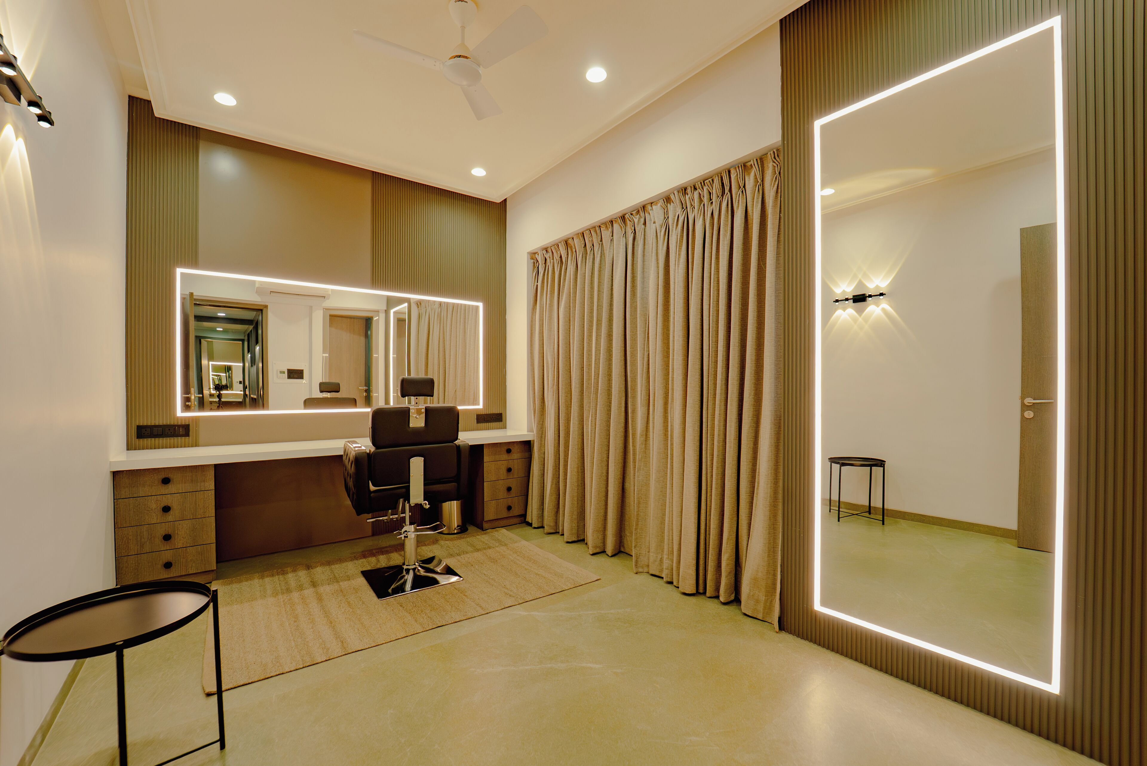 A modern bedroom with a large mirror, a desk, and a chair.