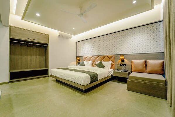 Un dormitorio moderno con cama, mesita de noche y un banco empotrado.