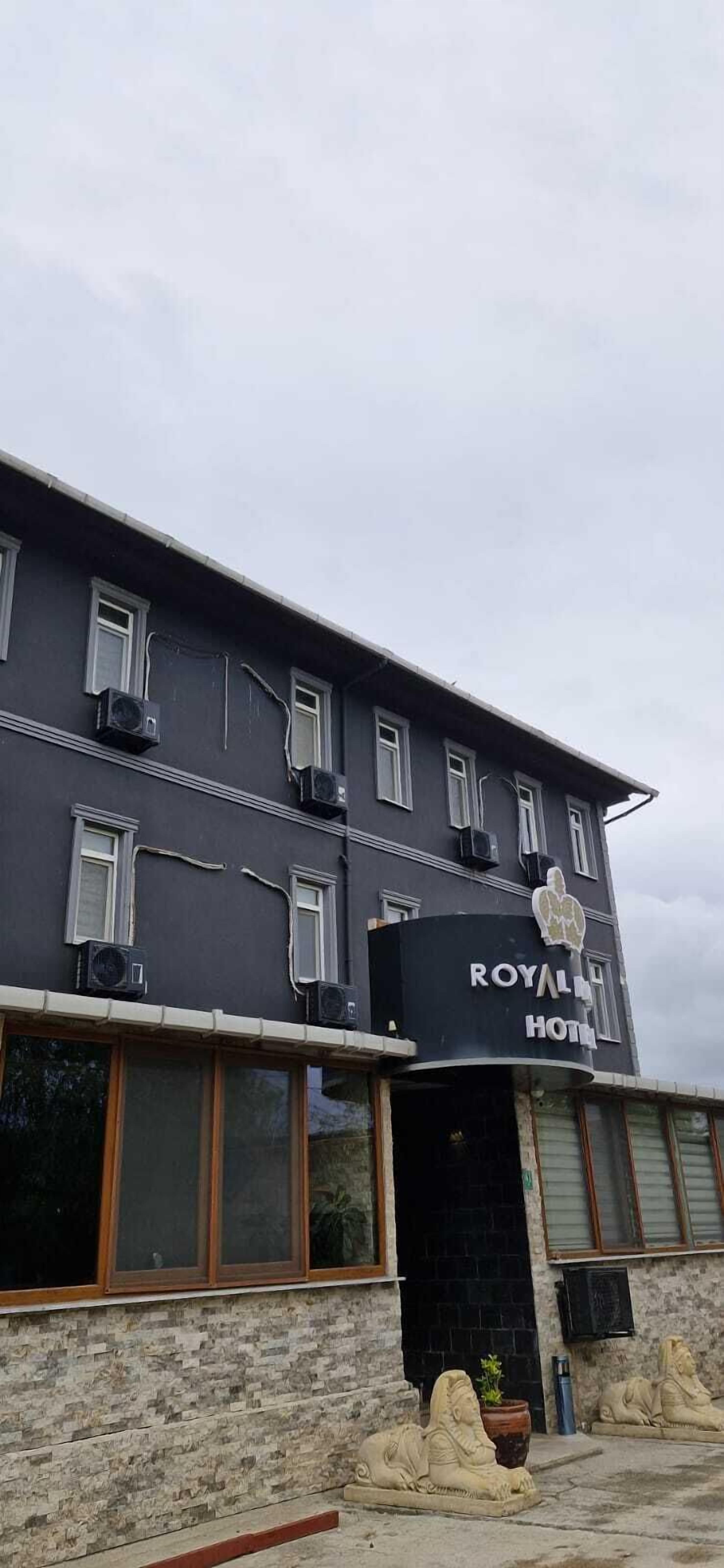 Un edificio con un cartello che riporta "ROYAL HOTEL" e diversi condizionatori d'aria sulla facciata.