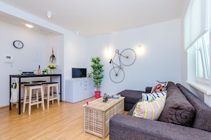 Ein modernes Wohnzimmer mit einer Couch, einem Couchtisch und einem Essbereich mit Hockern.