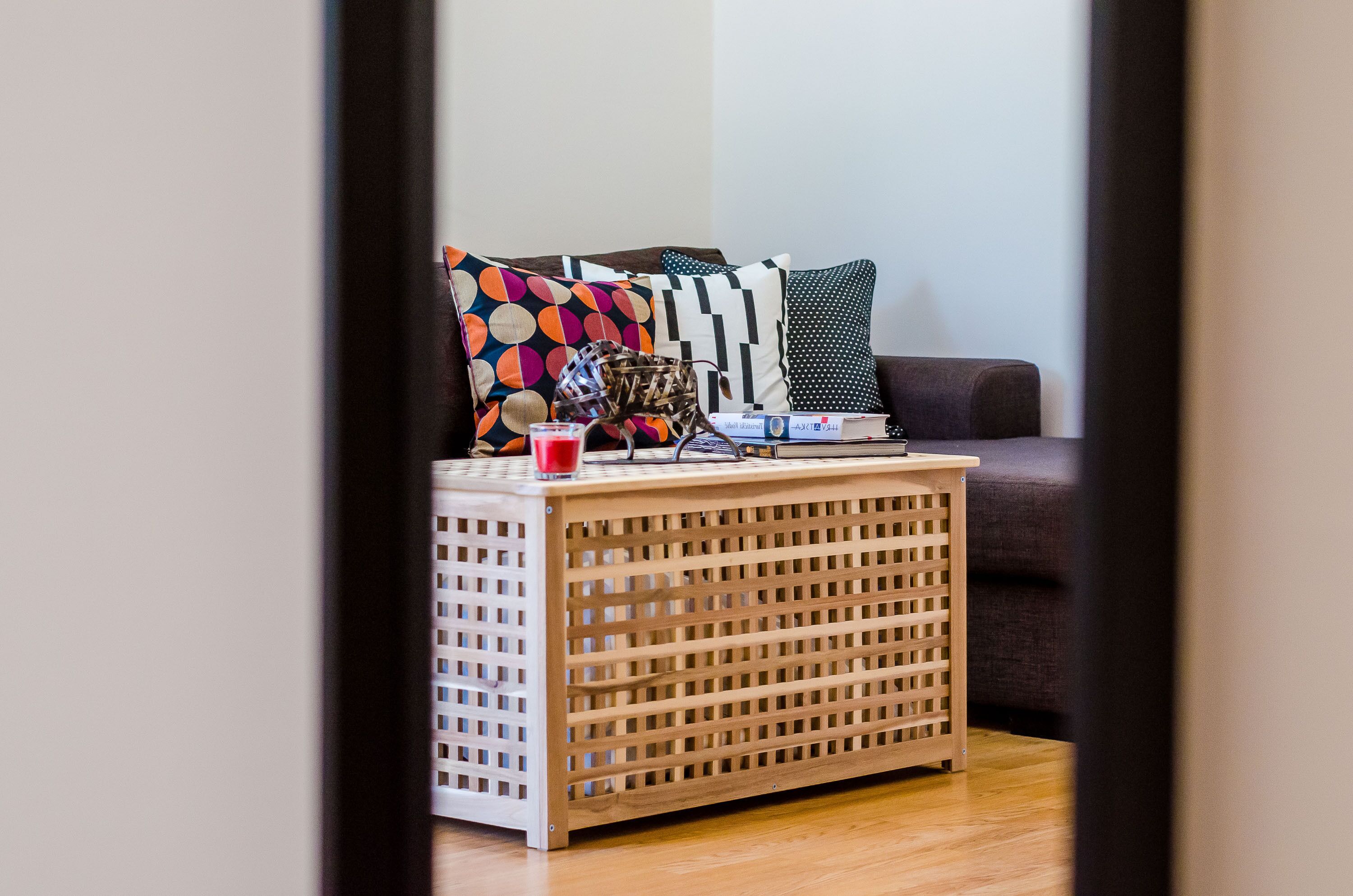 A room with a wooden side table, a red cup, and a stack of books.