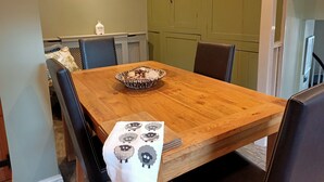 A dining area with a wooden table, chairs, and a decorative bowl. - Beautiful 2 bedroom spacious Cottage in the heart of historic Richmond  (Richmond)