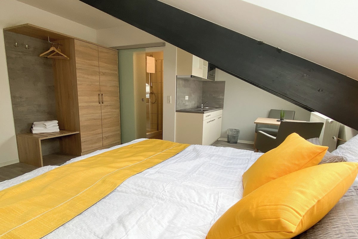 Une chambre comprenant un lit, une armoire, un coin cuisine et une salle de bain.
