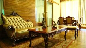 Un salón tradicional con un sofá, una mesa de centro y una mesa de comedor con sillas.