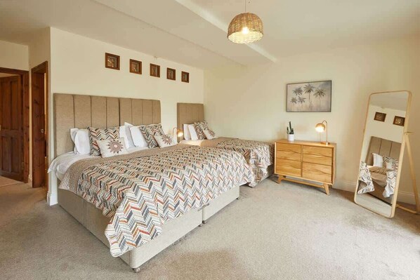 A bedroom with a large bed, a wooden dresser, a mirror, and a wall-mounted picture. - Host & Stay | Harbour View House (Whitby)