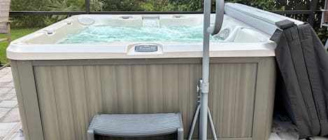 Un jacuzzi con un escalón y una manguera.