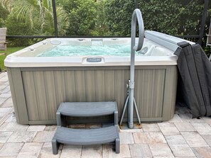 Ein Whirlpool mit Stufe und Schlauch.
