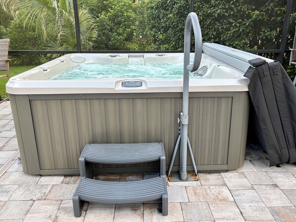 A hot tub with a step and a hose.