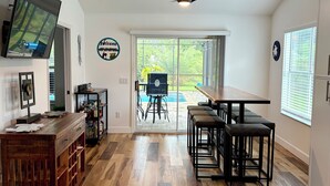A spacious kitchen with a large dining table, wooden flooring, and a ceiling fan. - Private Pool, HotTub and Golf Cart in the Village of Rio Grande! (The Villages)
