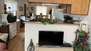 Un ambiente compatto con angolo cottura, un tavolo da pranzo e una televisione su un mobile.