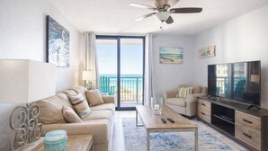 A modern living room with a sofa, coffee table, TV, and a balcony with a view.