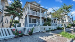 A two-story residential building with a balcony, white picket fence, and a clear blue sky. - Atlantic City ☆Waterfront Park☆ Amazing 360 views (Atlantic City)