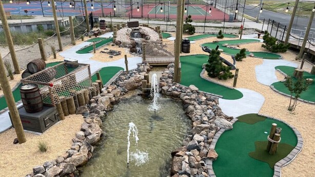 A miniature golf course with a water feature, green artificial turf, and a wooden bridge. - Atlantic City ☆Waterfront Park☆ Amazing 360 views (Atlantic City)