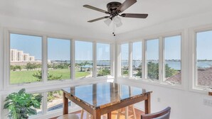 A spacious room with a large glass table, multiple windows, and a ceiling fan. - Atlantic City ☆Waterfront Park☆ Amazing 360 views (Atlantic City)