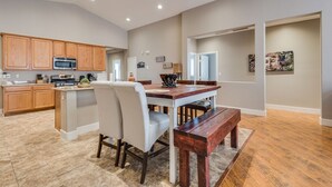 A spacious kitchen with wooden cabinets, a built-in microwave, and a dining area with a wooden table and chairs.