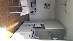 A kitchen with a built-in oven, a microwave, and a coffee machine. There is a clock on the wall and a window above the sink. - Accommodation in villa with large panoramic terrace (Imperia)