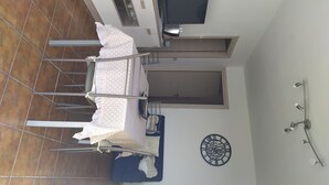 A room with a bed, a TV, a clock, and a ceiling fan. - Accommodation in villa with large panoramic terrace (Imperia)