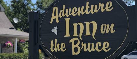 Señal de Adventure Inn en Bruce, con aviso de habitaciones disponibles.