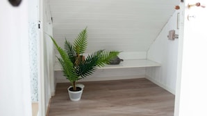 A narrow hallway with wooden flooring and white walls.