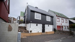 A two-story building with a black and white facade, a visible number '32', and a 'KIOSK' sign on the right.
