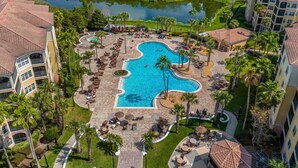 A resort with a pool, palm trees, and a lake. - Great View Condo, 2 Min. from Disney World!- 70 (Orlando)