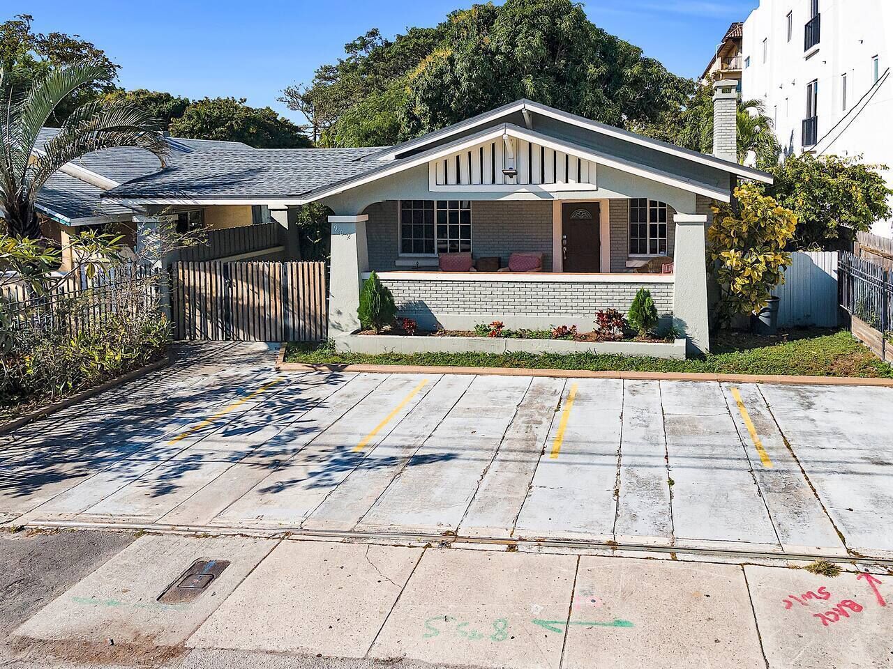 Ein Wohnhaus mit Veranda, Garage und Auffahrt.
