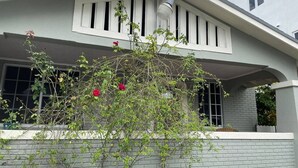 A residential building with a porch, a brick wall, and a window. - 1920s Bungalow Studio w/ Courtyard Oasis (Miami)