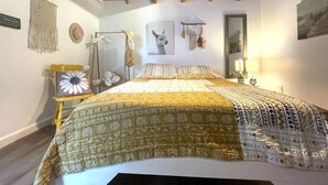 A bedroom with a bed, a hanging light fixture, a wall-mounted mirror, and a framed picture. - 1920s Bungalow Studio w/ Courtyard Oasis (Miami)
