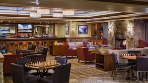 A spacious lobby with a bar area, comfortable seating, a fireplace, and a large screen. - SPRING BREAK Two-Bedroom Condo in Breck with private hot-tub! (Breckenridge)