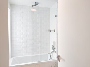 Bathtub, hair dryer, towels, shampoo