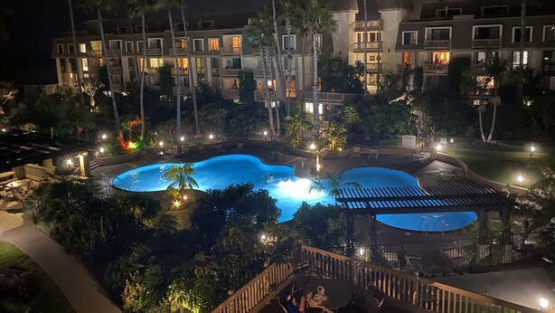 A hotel with multiple swimming pools, palm trees, and well-lit outdoor areas. - Northcoast Village Beautiful Penthouse w/ large rooftop deck and VIEWS! (Oceanside)